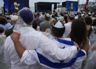 Тысячи людей собрались на пляже в Сиднее, чтобы почтить память жертв нападения на еврейский фестиваль